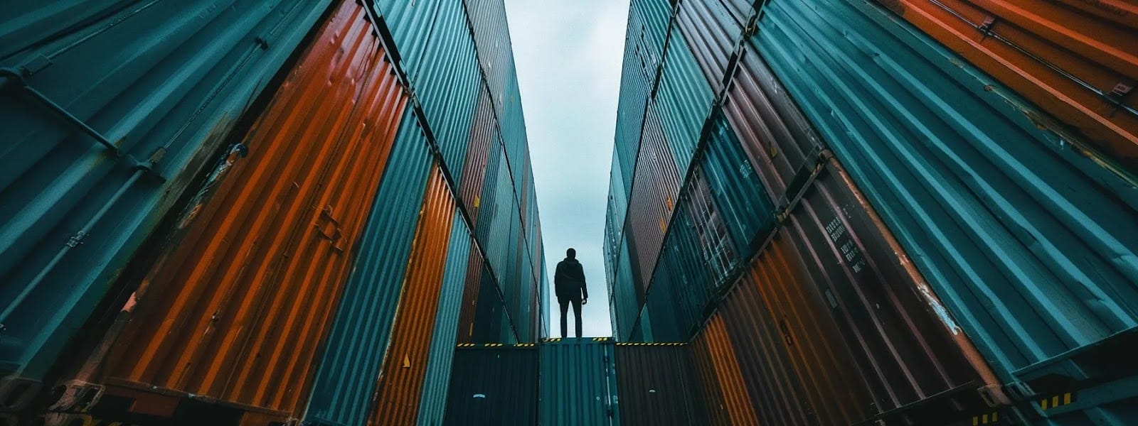 a determined individual navigating a maze of shipping containers, confidently addressing challenges in international shipping.